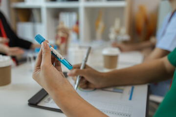 the three doctors are meeting to exchange new knowledge and information they have gained form their medical seminars with each other, a senior doctor is explaining information and knowledge