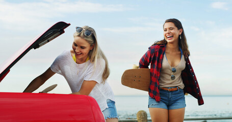 Obraz premium Beach, travel and women with car, smile and bonding together with tourism, vacation and nature. Road trip, people and friends with vehicle, ocean and adventure with journey, summer holiday and Miami