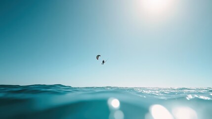 Vibrant photo of a kiteboarding scene on a sunny day. Clear blue sky and calm water creating a thrilling atmosphere. Emphasizing sport and freedom. Perfect for water sports and adventure content.