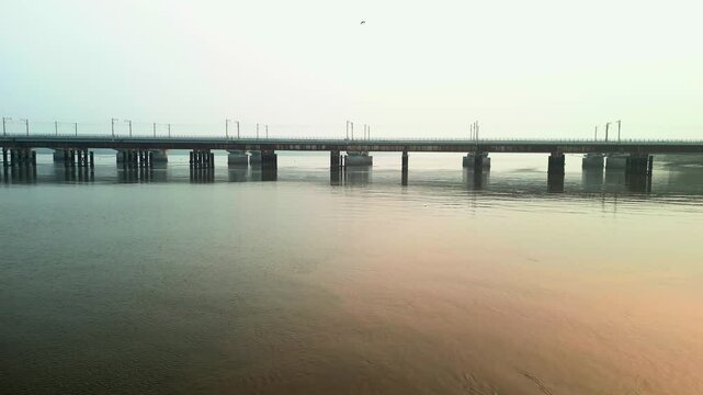 train going on vasai creek bridge side wide drone view.