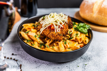 Crispy breaded chicken served over penne pasta tossed in a spicy arrabbiata sauce, topped with fresh basil and shredded mozzarella cheese.