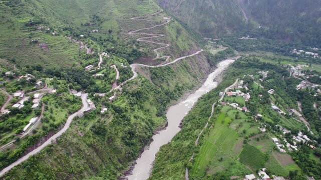 Kishan Ganga River winding road in a lush green MuzaffarAbad valley surrounded by steep mountains in Kashmir, Pakistan