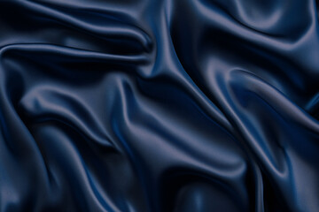 Obraz premium Dark blue silk satin background. Beautiful soft wavy folds on smooth shiny fabric.