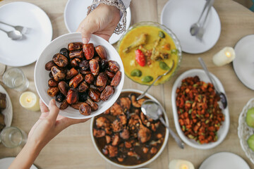 Top View Of Two Hands Giving And Receiving A Plate Of Dates Fruit For Family At Iftar Time On Ramadan Kareem 