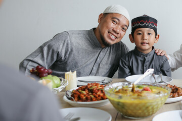 Portrait Of Father And Son Smiling At Camera During Eid Mubarak Celebration 
