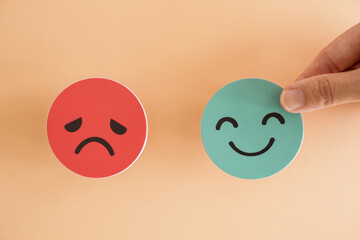 Hands holding sad face hiding behind happy face, bipolar and depression, mental health, split...