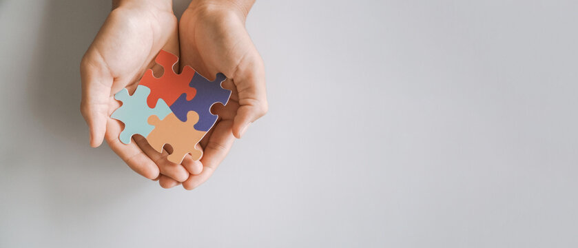 hands holding jigsaw puzzle heart shape, Autism awareness,Autism spectrum disorder family support concept, World Autism Awareness Day.