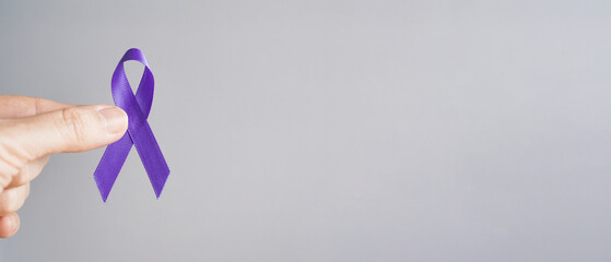 Hands holding purple ribbon, Alzheimer's disease, Pancreatic cancer, Epilepsy awareness, world cancer day, concept.