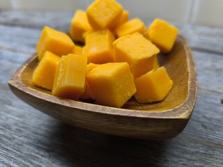 diced cheese lies in a wooden plate