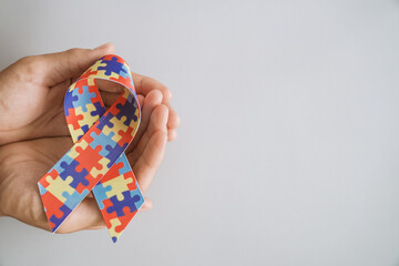 hands holding jigsaw puzzle ribbon, Autism awareness,Autism spectrum disorder family support concept, World Autism Awareness Day.