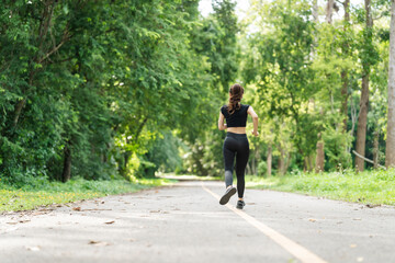 A woman in sportswear running in the park, enjoying fresh air, engaging in outdoor activities to maintain a healthy lifestyle, boosting cardiovascular health, and feeling happy and energetic