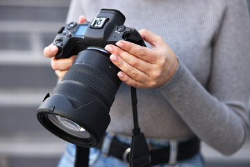 Professional photographer with digital camera outdoors, closeup