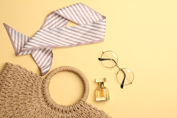 Beautiful bag, perfume and stylish accessories on beige background, flat lay. Space for text