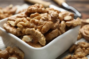 Peeled walnuts in bowl on table, closeup
