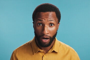 Portrait, surprise and wow with black man, facial expression and announcement on blue studio...