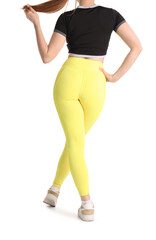 Young woman in sportswear on white background, back view