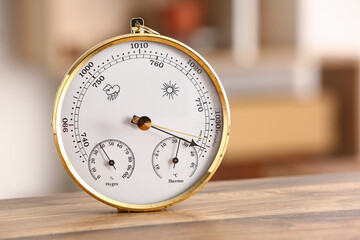 Aneroid barometer on wooden table in room, closeup