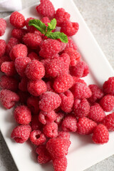 Plate with fresh raspberries and mint, closeup