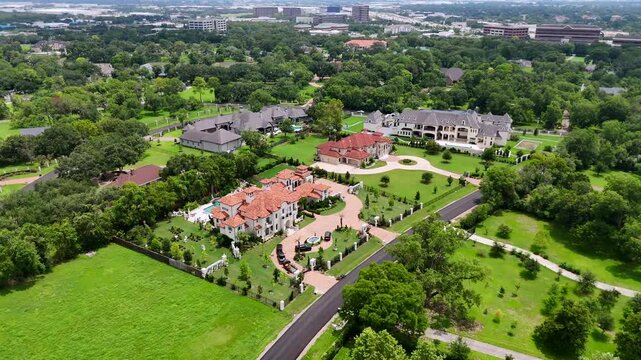 An aerial view of multiple mansions and estates, on a sunny day.