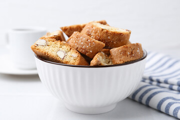Traditional Italian almond biscuits (Cantucci) in bowl on white table, closeup