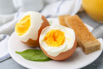 Fototapeta premium Soft boiled eggs with bread on grey table, closeup