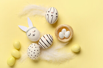 Composition with different creative Easter eggs and feathers on beige background