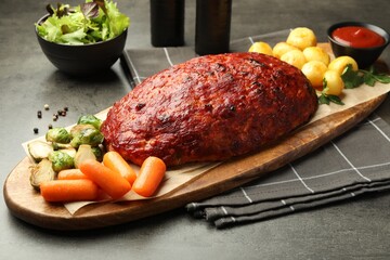 Delicious turkey meatloaf with vegetables on grey table, closeup