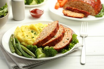 Delicious baked turkey meatloaf with mashed potato served on white wooden table, closeup