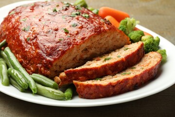 Delicious baked turkey meatloaf with vegetables on table, closeup