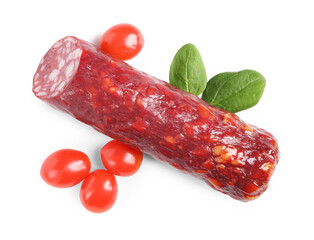 Piece of delicious dry cured sausage with basil and tomatoes isolated on white, top view