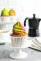 Delicious cupcake with colorful cream on grey textured table, closeup