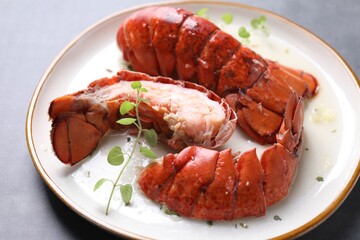 Delicious tails of boiled lobsters served on grey table, closeup