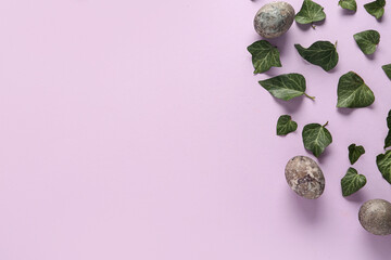 Eucalyptus leaves and painted Easter eggs on lilac background