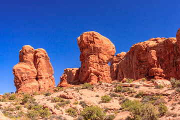 Fototapeta premium A rocky landscape with three large rocks, each with a distinct shape