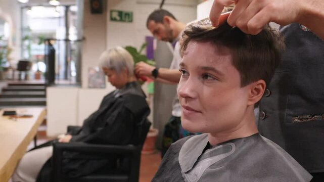 Professional hairdresser skillfully styling short hair at salon