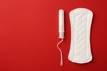 Menstrual pad and tampon on red background, top view. Space for text