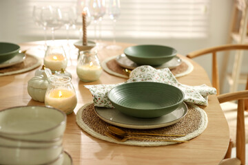 Stylish table setting with dishware, cutlery and burning candles indoors