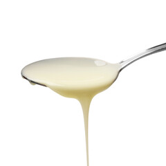 Delicious condensed milk pouring from spoon isolated on white