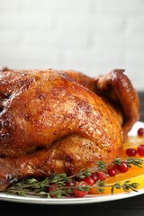 Delicious baked turkey, orange slices, cranberries and thyme on table, closeup