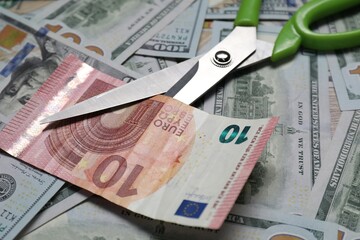 Different banknotes and scissors as background, closeup