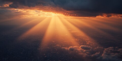Captivating aerial shot of sun rays piercing through clouds, illuminating a sprawling cityscape at sunset.