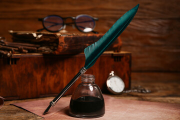 Old paper sheets with nib pen, inkwell and pocket watch on wooden background