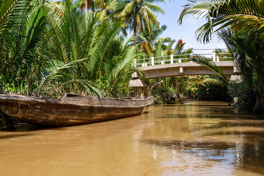 boat tied trees river bridge