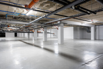 Empty underground parking lot with industrial features and bright lights during the day
