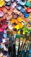 Fototapeta premium Close-up of colorful paint tubes, brushes and a messy palette, showing the vibrant hues ready for the artist's work.