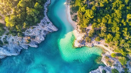 Aerial view of a secluded cove with turquoise water, white sand beach, and lush green vegetation.