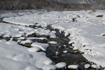 雪が積もった冬の川　清流　長野県白馬村