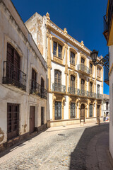 Obraz premium Ronda town in Spain. Charming cobblestone street with a historic building. Sunlight illuminates the aged stone and ornate architecture of the building.