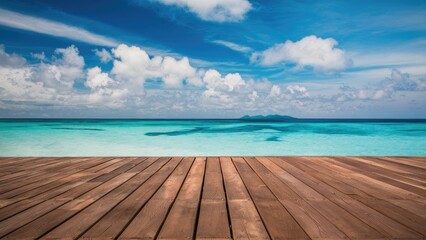 Fototapeta premium Serene ocean view with clear turquoise water and blue sky, contrasting with a warm brown wooden floor in the foreground under fluffy clouds