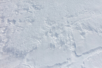 A snow covered ground with a few footprints